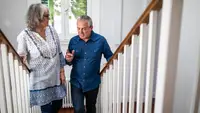 Two senior adults climb the stairs.