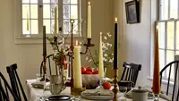 A variety of tall candles on a dining room table