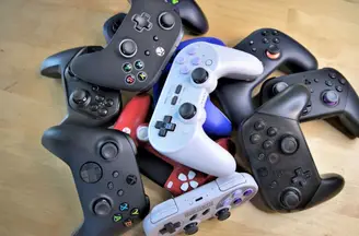 A pile of PC game controllers on a desk
