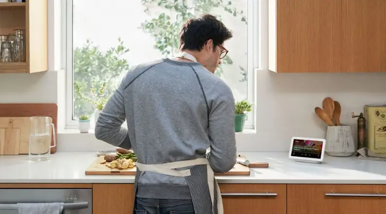 Man in kitchen with Google Nest Hub