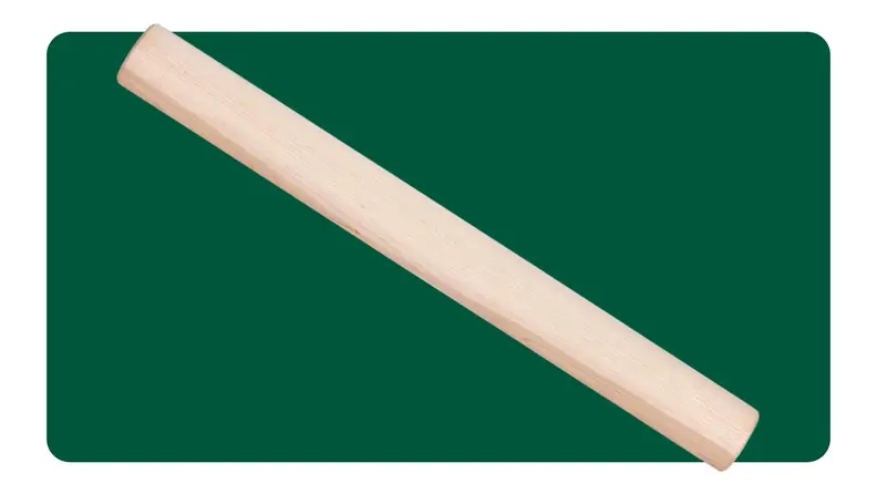 Two hand peeling an apple on a cutting board, with a rolling pin closeby