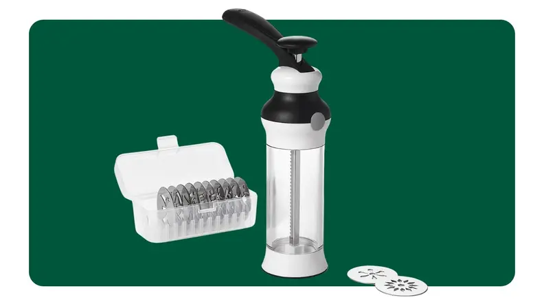 On left, hand spooning dough into cookie press. On right, cookie press filled with batter surrounded by stainless steel designed discs