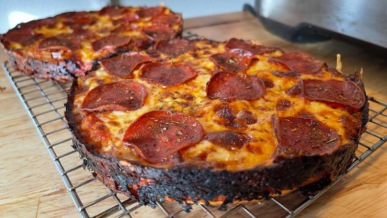 Two pan pizzas on a cooling rack.
