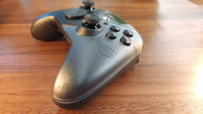 Sleek black Asus Rakiri Pro controller on top of wooden surface.