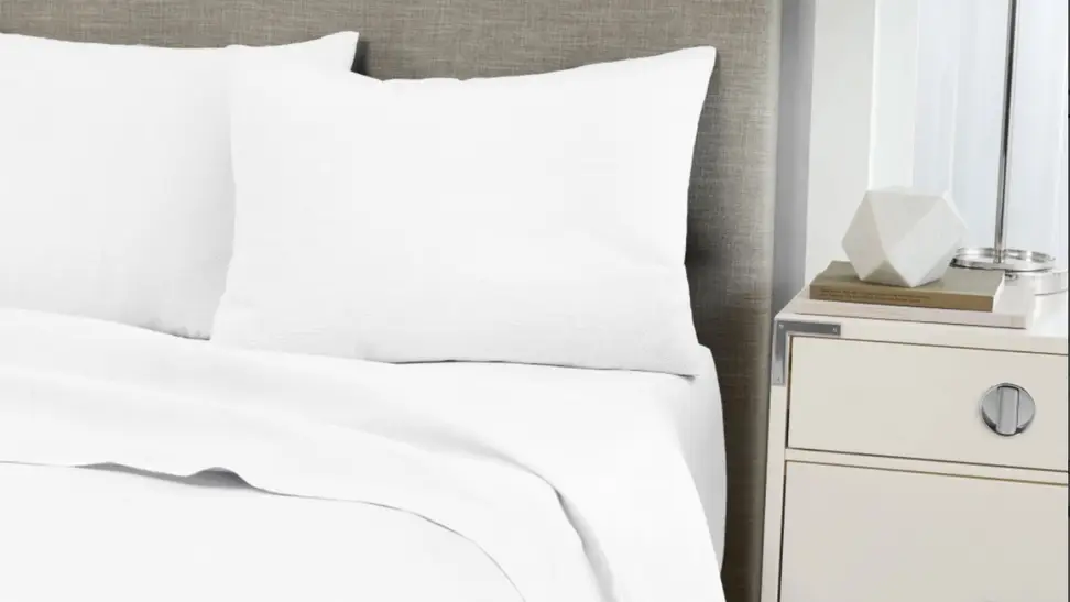 Standard textile home sheets on a made bed