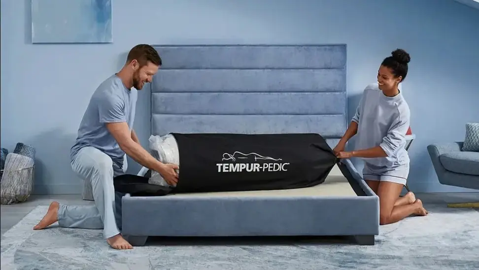 a couple open the Tempur-Pedic Cloud on their bed frame